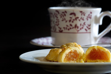 English tea in cup and fruits pie in plate on dark background