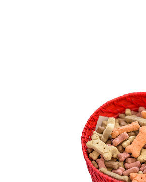 Colorful Dog Treats Bone Shaped in Red Bowl with White Space for Copy Text 