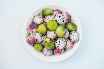Tasty fruit dessert. Dragon fruit and kiwi balls in bowl isolated over white background. Exotic fruit salad. Carving concept. Ripe pitahaya in form of balls
