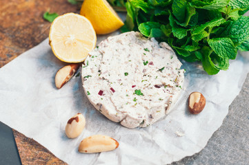 Vegan cheese on white napkin with brazilian nut, mint and lemon. Vegeterian food. Horizontal shot. Special cuisine. Nutcheese