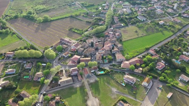 Aerial drone shot over the village Campagne in France sunset time old village with green trees and vineyards fields around