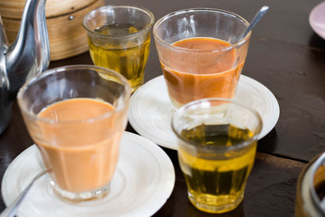 Thai tradition hot tea with sweetened condensed milk in old style cup (Selective focus)