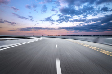 Fototapeta premium Motion-blurred highway in dusk clouds