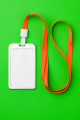 Fototapeta premium Blank security tag with a red stripe neck on a green background. Place for text, layout