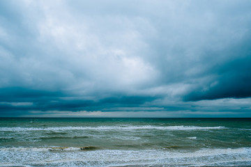 Windy storm beach seashore seaside sea waves dark clouds