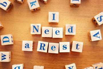 I need a rest. Conceptual image with the text made from wooden cubes on a desk