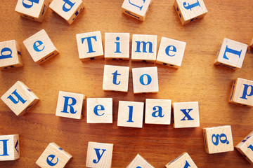 Time to relax. Conceptual image with the text made from wooden cubes on a desk
