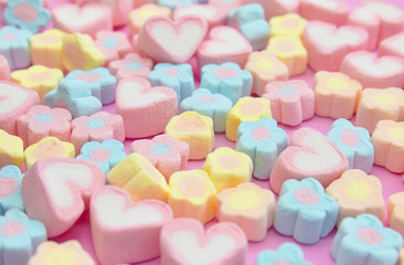 Selective focus colorful fluffy marshmallows on pink background, sweet dessert fudge