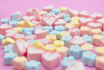 Closeup with selective focus colorful fluffy marshmallows on pink background