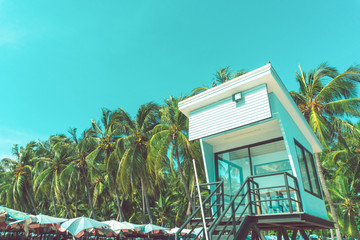 Beach sunrise with lifeguard tower and coastline with colorful cloud and blue sky.
