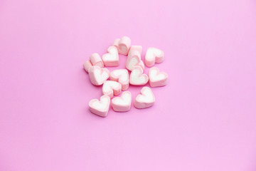 Obraz na płótnie Canvas Top view flat lay design of pastel pink color marshmallows on pink background with copy space