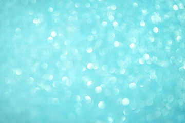 Blurred bokeh light blue party background, Christmas and New Year holidays background. Party concept. Festive holiday card bright backdrop. Defocused. Flat lay, top view, copy space.
