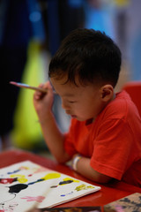 kid is drawing artwork by coloring and drawing