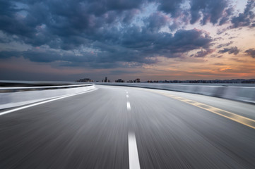 Fototapeta premium Motion-blurred highway in dusk clouds