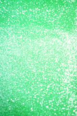 Blurred bokeh light green party background, Christmas and New Year holidays background. Party concept. Festive holiday card bright backdrop. Defocused. Flat lay, top view, copy space.