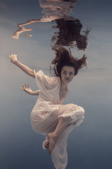 The girl in the white dress swims under water