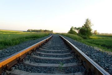 The canvas of the railway leaving far into the distance and illuminated by the setting sun