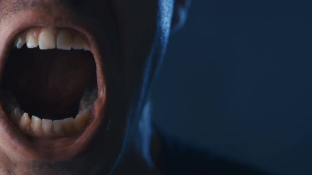 Close-up mouth of Aggressive Man screaming. Danger Violence. Angry man Shouting with Mouth wide open.