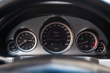 The interior of the car with a view of the steering wheel, dashboard, speedometer and tachometer...