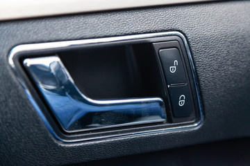 Obraz premium The interior of the car with a view of the door panel, handle and lock buttons with light gray trim