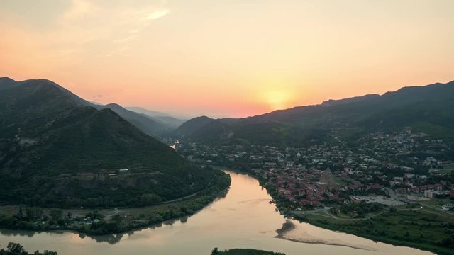 Beautiful timelapse of sun setting over mountains behind the old Georgian town Mtskheta.