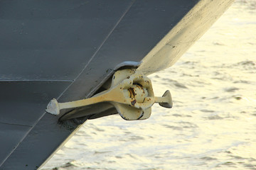 Rusty anchor on the gray stem of the ship