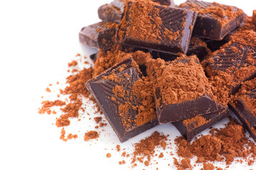 Broken dark chocolate with cocoa powder