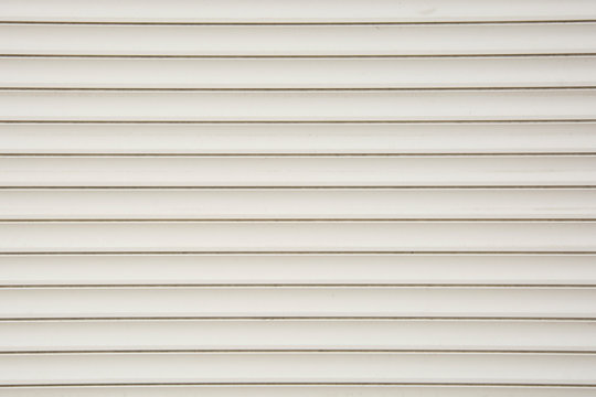 Close up of a roller shutter door, plastic white texture background