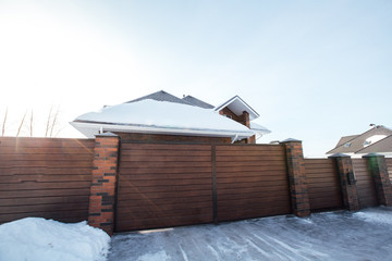 cottage in the winter with a fence