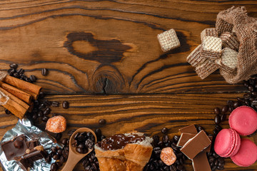 Desserts for tea. Waffles, croissants, oatmeal cookies, chocolate, cinnamons, macaroons on the wooden table