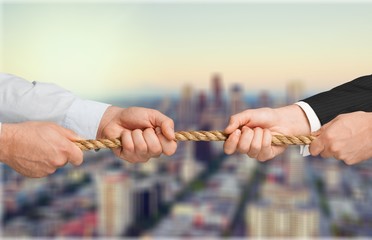 Tug war, two businessman pulling a rope in opposite directions isolated on white background