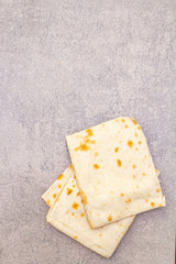 Pita bread lavash on a stone background. Food cooking background, wallpaper, top view.