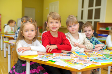 children sit at the desk in a lesson in a kindergarten