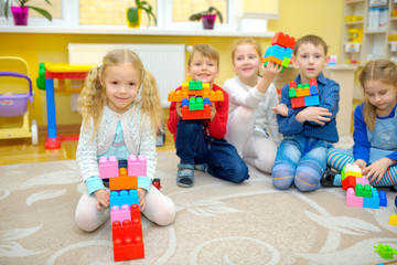 educational games for children, a group of children playing on the floor in kindergarten, folding constructor