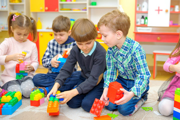 educational games for children, a group of children playing on the floor in kindergarten, folding constructor