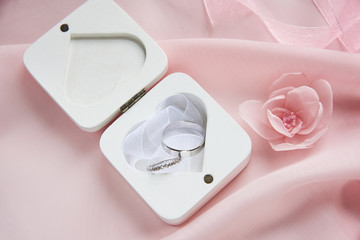 white box for wedding rings on pink chiffon - close-up top view