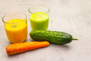 Organic cucumber and carrot smoothies with sesame and chia seeds. Healthy diet concept. On a stone background, copy space.
