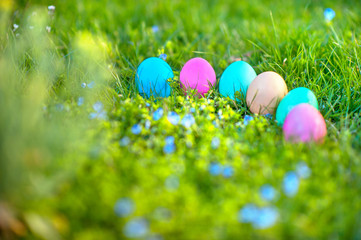 Colorful decorative easter eggs lie on the grass, easter holiday