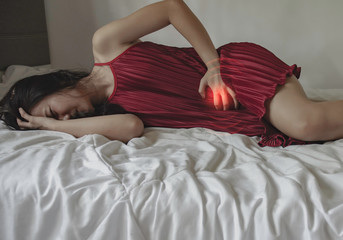 Asian girl has abdominal pain.When is menstruation.Catch his stomach.Women have bladder pain.Warm...