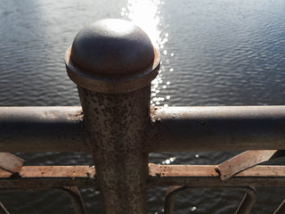 Metal bridge and river. Railing old metal bridge. Rusty iron bridge.