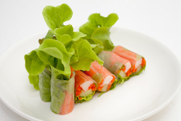 Salad roll on a wood dish in white background