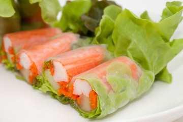 Salad roll on a wood dish in white background