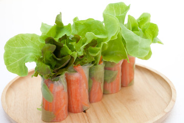 Salad roll on a wood dish in white background