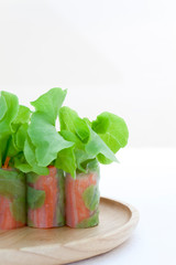 Salad roll on a wood dish in white background