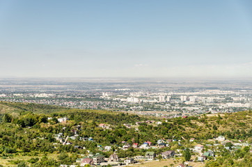 View from a high mountain on the city of Almaty. In the foreground in Lemsa country houses and villas.