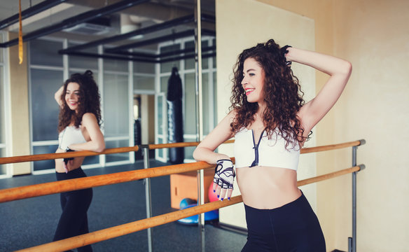 Young curly woman with resting after work out in gym