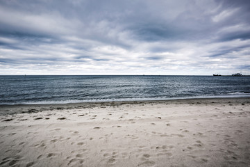 Fototapeta na wymiar Empty beach background of free space and ocean landscape with dark sky 