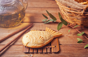 Taiyaki Japanese street food fish-shaped sweet filling waffle on wooden table
