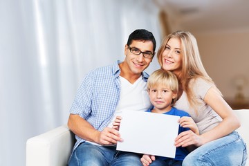 Beautiful smiling family sitting at sofa at