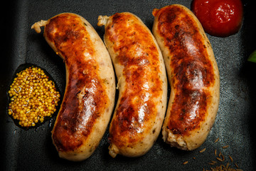 top view closeup square pan with three fried sausages